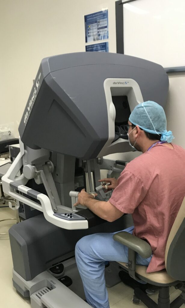 Dr. Thiago Teixeira realizando cirurgia robótica Da Vinci, um procedimento minimamente invasivo de alta precisão na urologia.